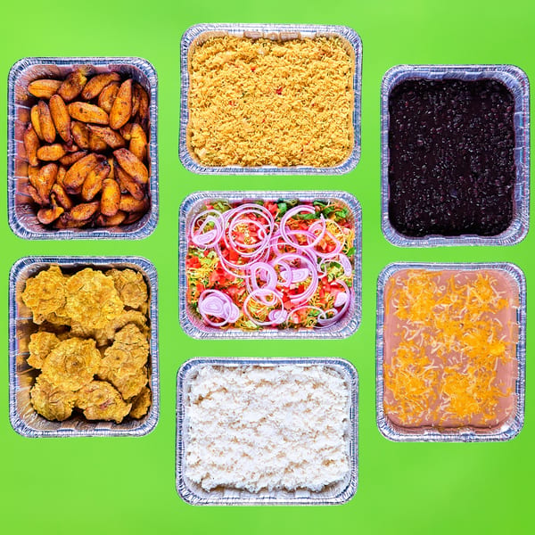 Seven catering trays of Mexican food including plantains, rice, beans, salad, and refried beans.