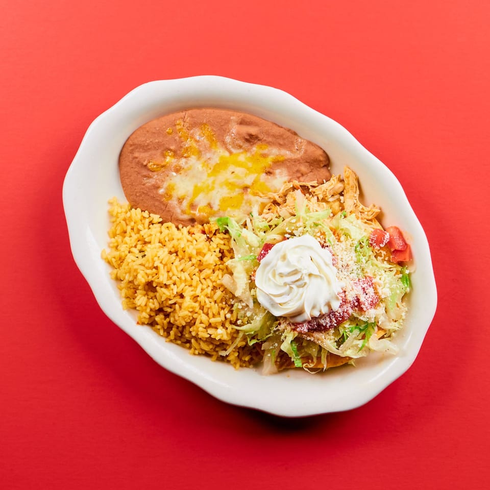 La Bamba's Mexican dish with refried beans, rice, shredded chicken, lettuce, tomatoes, and sour cream.